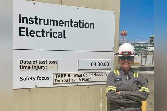 Liz Stone in front of the instrumentation electrical sign at Boron operations in California