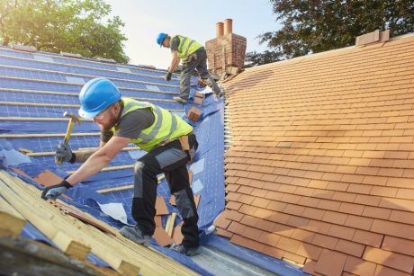 Construction workers laying roof tiles that contain boron