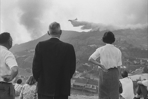 People watching an airplane drop fire retardants on the Bel Air fire in California